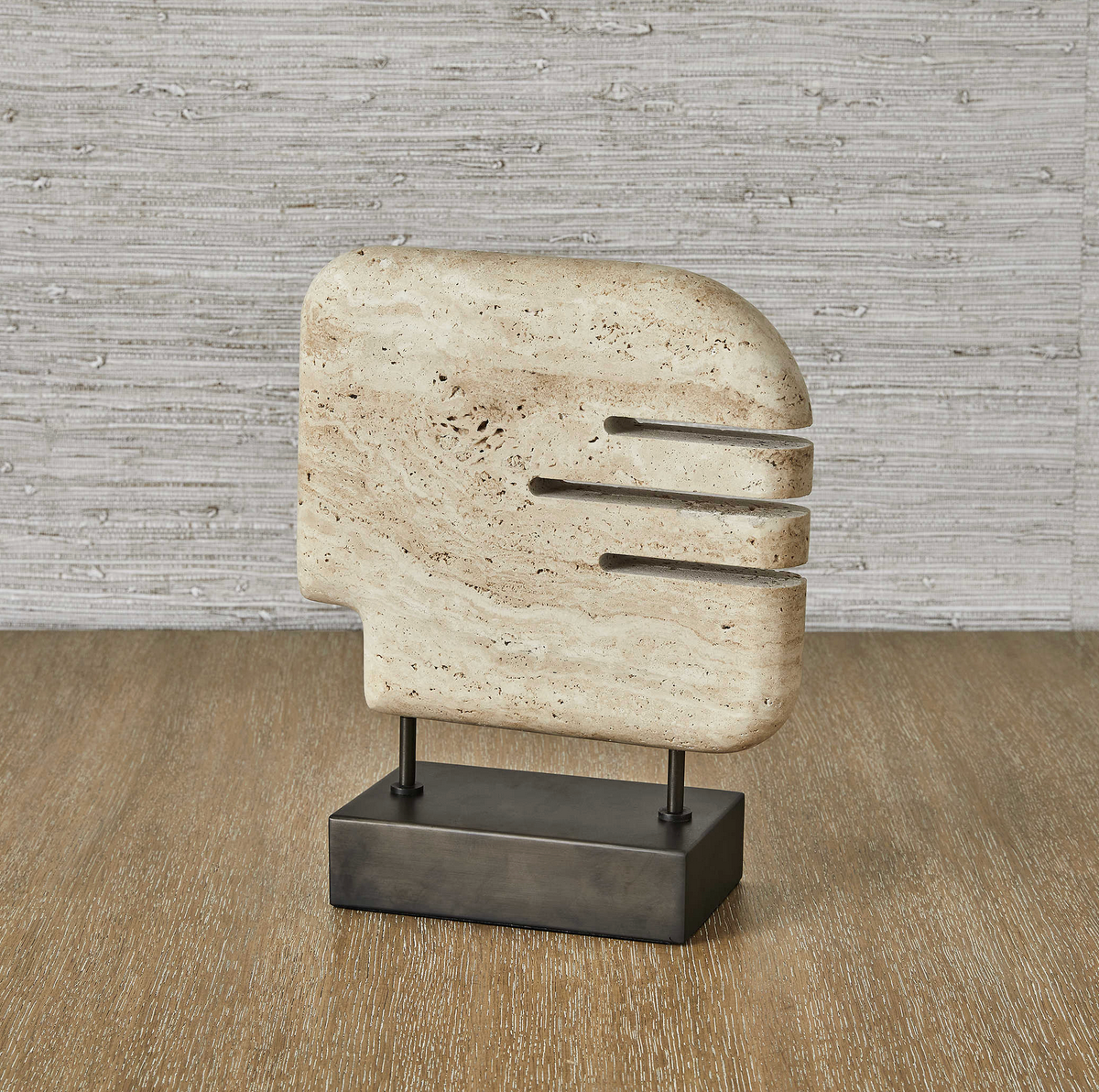 Icon-inspired and carved of beige unfilled travertine, this work is set on a bronzed steel base for a study in contrasts. Textured vs smooth, light vs dark: the interplay invites a closer look whether displayed alone or as part of a grouping.