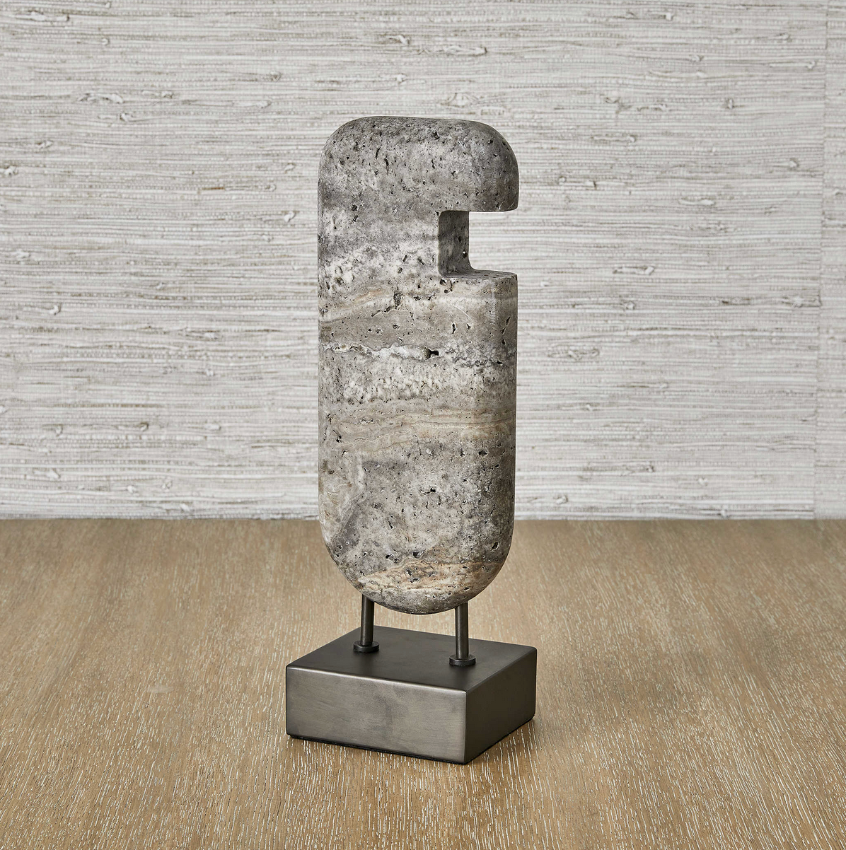 Icon-inspired and carved of gray unfilled travertine, this work is set on a bronzed steel base for a study in contrasts. Textured vs smooth, cool vs warm: the interplay invites a closer look whether displayed alone or as part of a grouping.