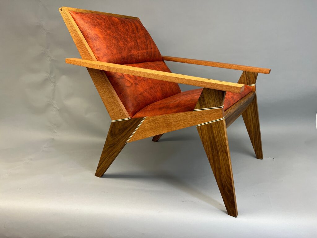 Mandarin leather, Lacewood and Shedua woods with Ambrosia Maple and Wenge accents, upholstered back.