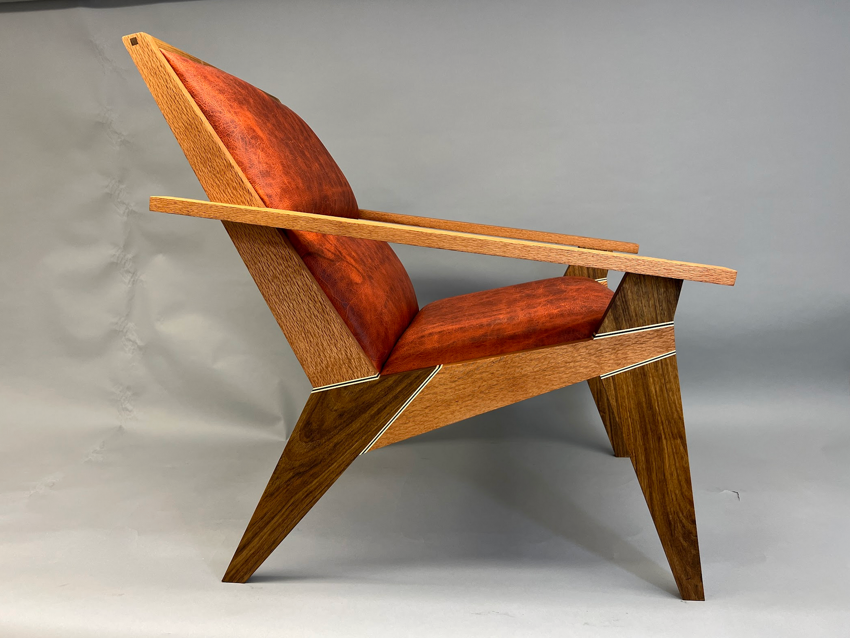 Mandarin leather, Lacewood and Shedua woods with Ambrosia Maple and Wenge accents, upholstered back.