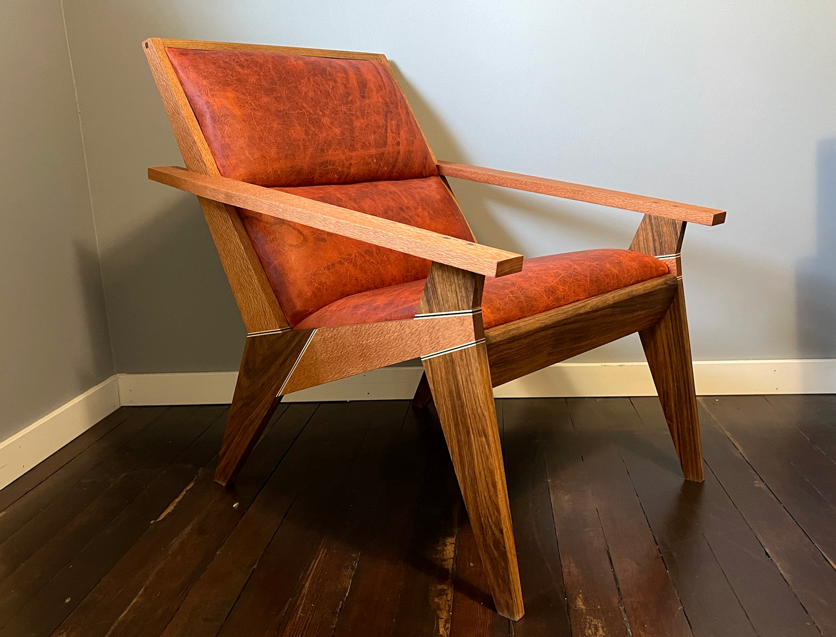 Mandarin leather, Lacewood and Shedua woods with Ambrosia Maple and Wenge accents, upholstered back.