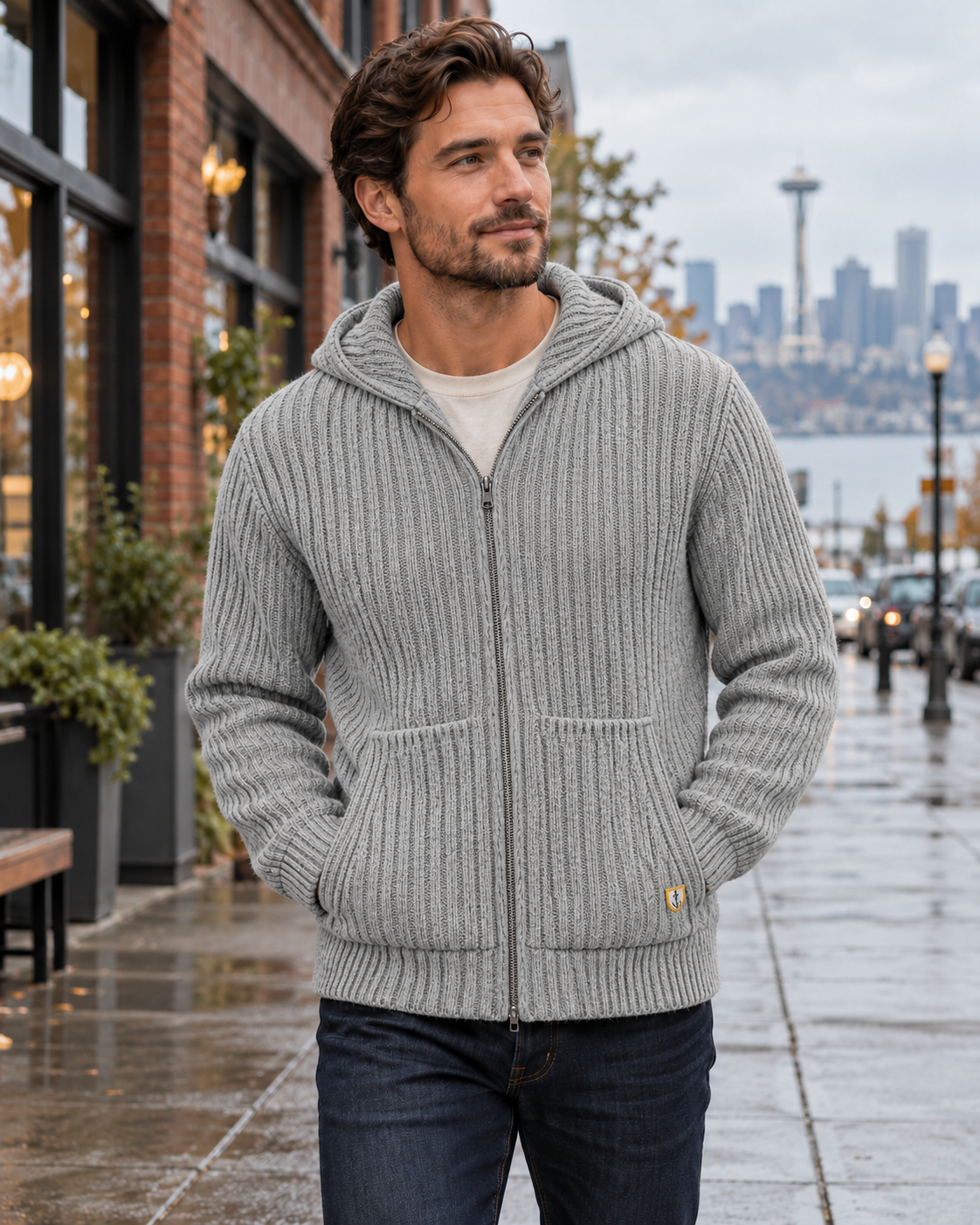 Male model wearing a light heather slate Armor Lux hooded wool cardigan in Seattle